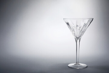 Elegant empty martini glass on grey background. Space for text