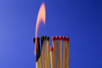 Burning and whole matches on blue background. Stop destruction concept