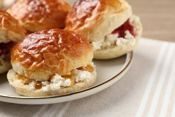 Freshly baked soda water scones with cranberry jam and butter on table, closeup