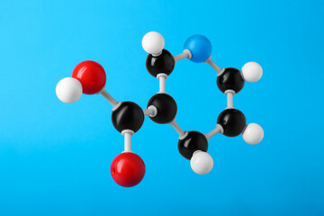 Molecule of vitamin B3 on light blue background. Chemical model