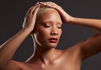 Naklejka premium Skincare, makeup and black woman with hands on head in dark studio, platinum hair isolated on grey background. Art aesthetic, cosmetics and African beauty model and luxury spa facial for bronze skin.