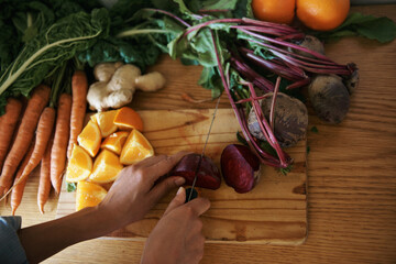 To eat is a necessity, but to eat intelligently is an art. a woman slicing fruit and vegetables on...