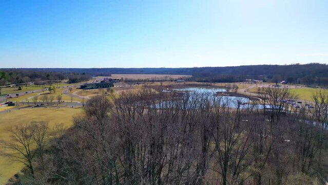 Flying over trees, revealing fishing pond and Wilma Rudolph Event Center in Clarksville Tennessee