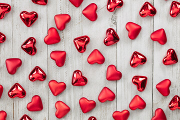 Little red hearts on white wood background. Love concept.