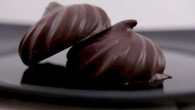 Delicious chocolate covered marshmallows with mint on black table, flat lay. Space for text. High quality photo