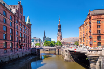 Fototapeta na wymiar Speicherstadt in Hamburg with Tower of St. Catherine's Church