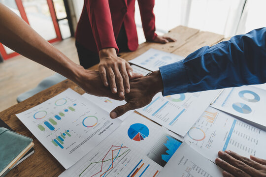 business team join hands Agree to work as a team to work together in finance. investment of real estate projects meetings summarizing results from graphs charts seamless management within the office.