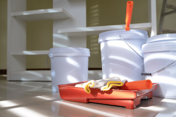Paint bucket, paint tray, paint roller with metal stepladder in interior room preparing for painting wall, fixing and renovation room by self at home, house or apartment. Home renovation self concept.