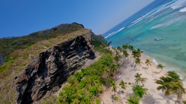 Aerial around huge cliffs over the beach of fronton in the Dominican republic, fpv