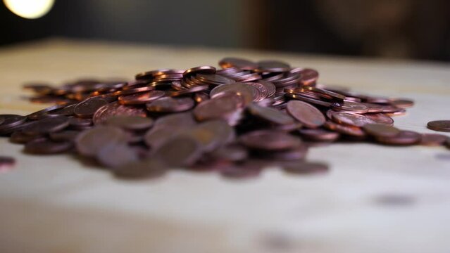 Pile of cent coins on wooden table with dark background and bokee