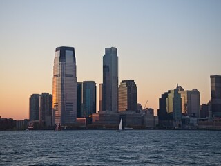 The high rises of Jersey City tower over the Hudson River at dusk