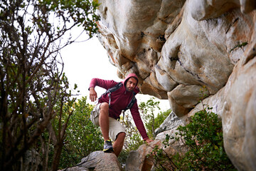 Treacherous terrain. a young man enjoying a hike through the mountains.