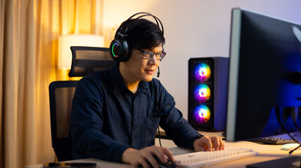 Happy excited successful businessman in modern home office with headphone  desktop computer,...