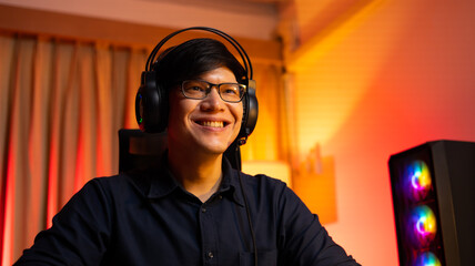 Professional Asian male gamer playing video games on personal pc computer. Colorful neon light room. Esport online game.