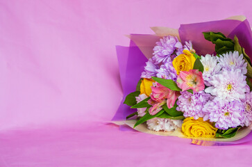 Beautiful bouquet with flowers on a pink background. There is space for text. Spring background for banner, advertisement, postcard.
