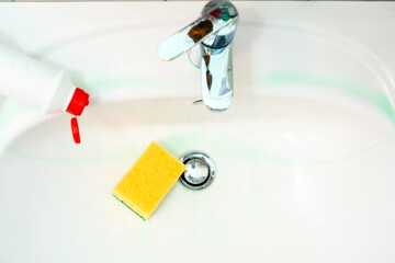 Cleaning plumbing with cleaning products, glove sponge and plumbing.