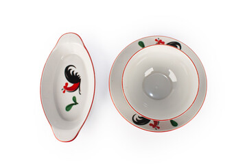 A set of white plates with a rooster design on it.  isolated with white background