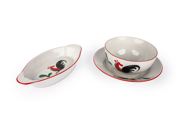 A set of white plates with a rooster design on it.  isolated with white background