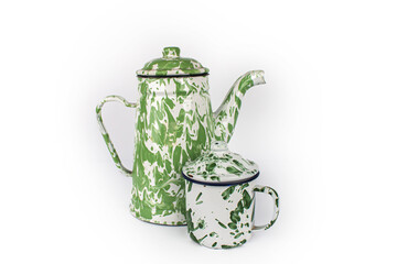 A vintage green white teapot and a small green cup are next to it. isolated on white background