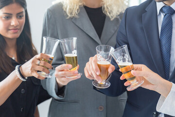 Corporate co-workers having drinks after meeting, People clinking glasses with sparkling wine indoors, Business people celebrating inside modern office.
