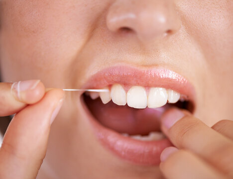 Taking care of her teeth. Closeup shot of a young woman flossing her teeth.