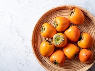 Persimmons on a wooden plate