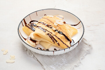 Homemade crepes, tasty thin pancakes with chocolate and nuts.