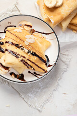 Homemade crepes, tasty thin pancakes with chocolate and nuts.