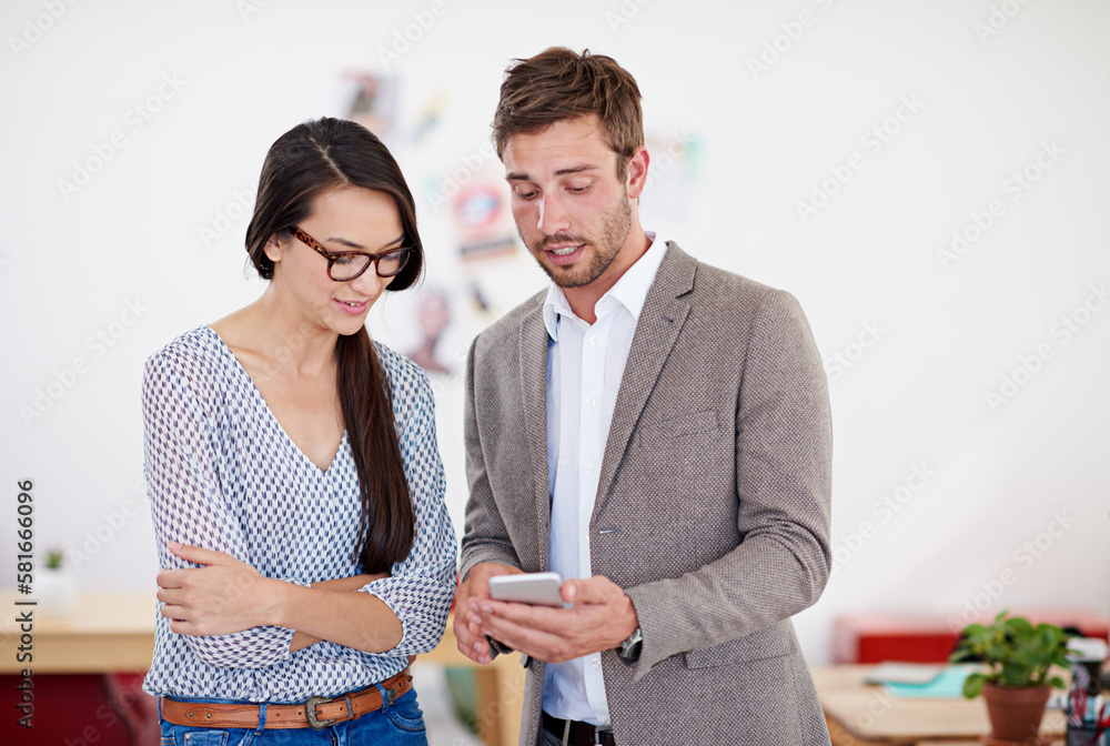 Poster comparing digital notes. two coworkers standing in an office looking at a digital tablet.