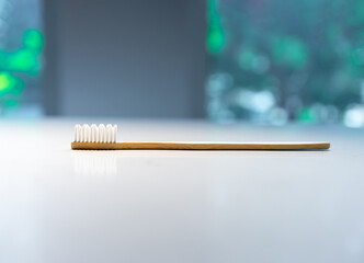 wooden toothbrush lays on white clear marble granite without anything beside.