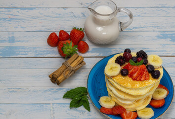 pancakes with red fruits and syrup