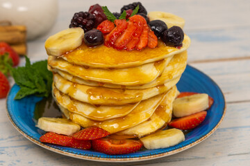 pancakes with red fruits and syrup