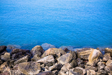 The beach and sea surface with Deep Blue sea clear sky clouds. Landscape with Ocean small waves water reflection copy space for text. Illustration for tourism, website or ad. Andaman sea, Thailand.