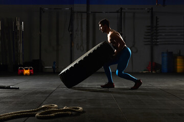 Man flipping over a tractor tire.