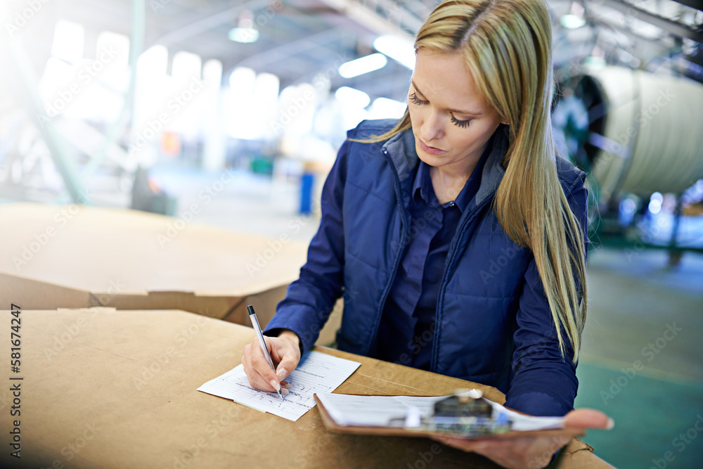 Poster Getting the manifest in order. a manager sorting paperwork while standing on the factory floor.