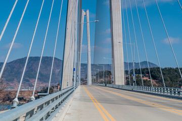 Fototapeta na wymiar Two lane road across cable stay suspension bridge in rural countryside.