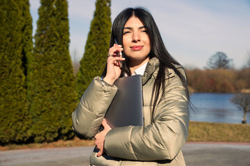 Portrait of a European business woman who is talking on the phone on the street