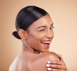 Indian woman, beauty and skincare portrait with wink, smile and looking over shoulder with...