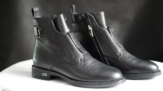 Demi-season women's shoes. A pair of ankle boots made of dark leather.