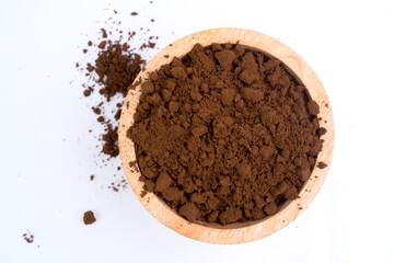 Coffee grounds in a wooden bowl isolated on white background.