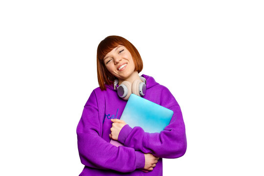 Smiling woman wearing headphones and holding a laptop
