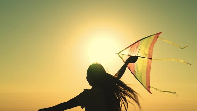 kite. colored rainbow kite hands girl with long hair. happy family. chidhood dream. girl park sunset playing with kite. child teenager journey. fantasy child. concept kite wind. play game nature.