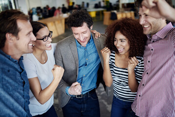Celebrating another team success. a group of coworkers celebrating together while standing in an...