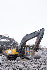 demolished buildings. Excavator working in debris removal work.