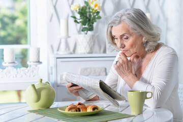 Obraz na płótnie Canvas Portrait of senior woman reading newspaper