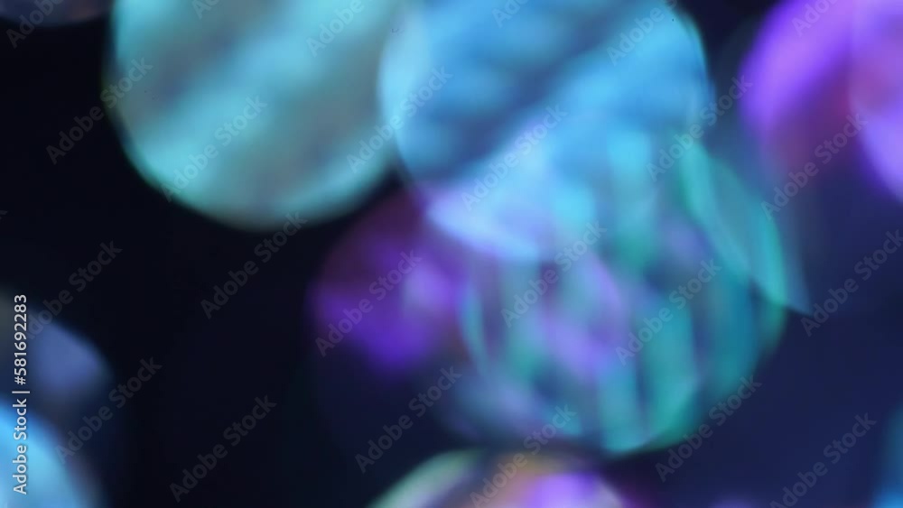Wall mural uneven shades of blue and purple bokeh. abstract motion background with defocused circles and light 