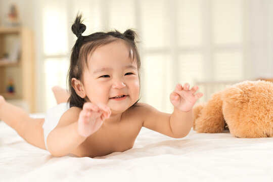 Lovely baby girls playing on the bed
