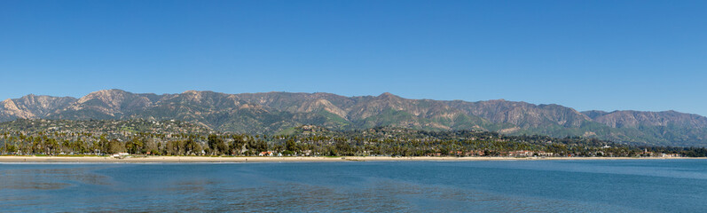 Fototapeta na wymiar view to scenic beach with palm trees in Santa Barbara with houses at the hills, California
