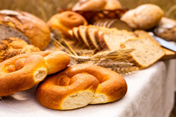 lot of different flavored bread, wheat, rye, on the table in the field outside