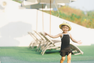 cute girl in dress black and yellow hat her in happy time play on grass ground